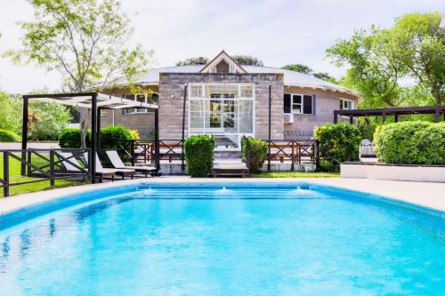 - une piscine en face d'une maison dans l'établissement Victoria Village, à Carilo