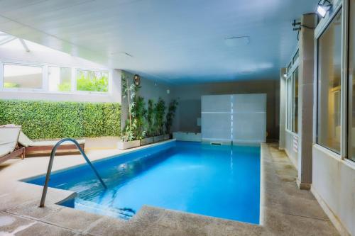 - une grande piscine d'eau bleue dans une maison dans l'établissement Victoria Village, à Carilo