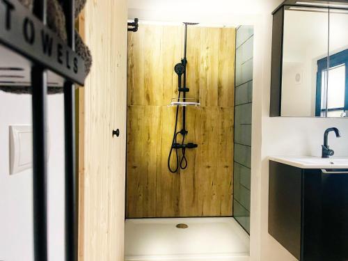 a shower with a wooden door in a bathroom at Godi's House in Vianden