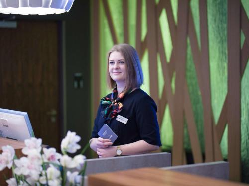 a woman standing next to a desk in a room at Mercure Lublin Centrum in Lublin