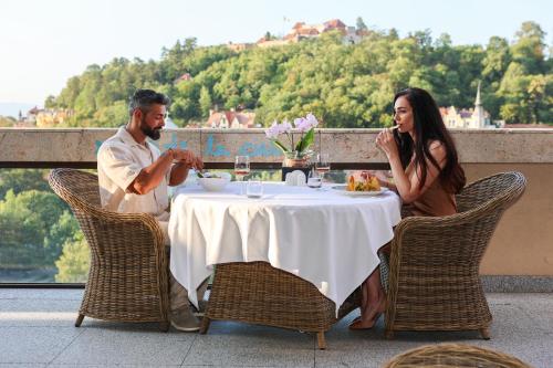 a man and a woman sitting at a table at Hotel Aro Palace in Braşov