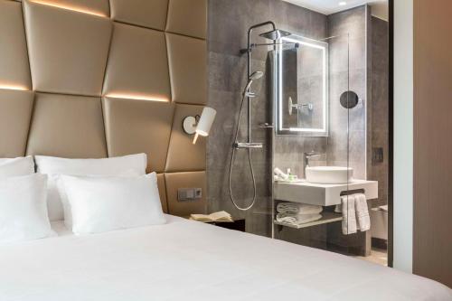 een hotelkamer met een bed en een douche bij NH Collection Eindhoven Centre in Eindhoven