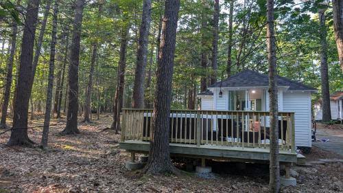 ein kleines weißes Haus mitten im Wald in der Unterkunft Hinckleys Dreamwood Cottages in Bar Harbor