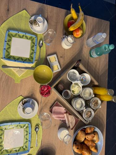 a wooden table with food and drinks and glasses at Chambre de la Wamme 2 in Marche-en-Famenne