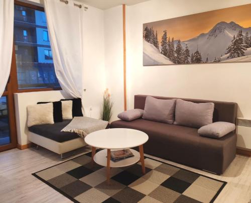 a living room with a couch and a table at Апартамент Four Seasons in Bansko