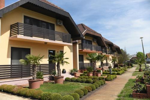 a row of houses with palm trees in front of them at Crystal Apartman in Mórahalom