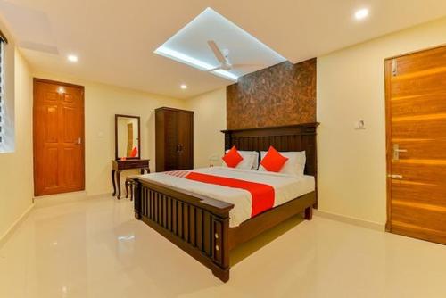 um quarto com uma cama grande e almofadas vermelhas em Fort Malabar Residency em Ernakulam