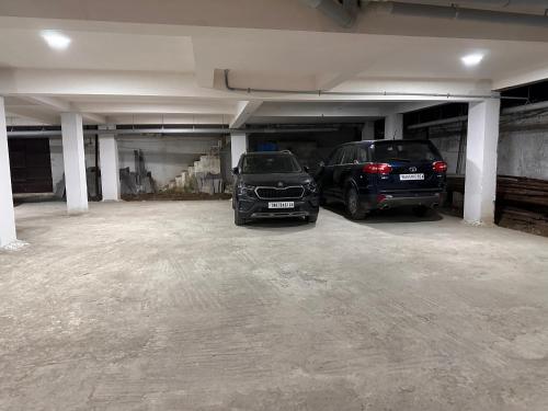 dois carros estacionados numa garagem vazia em MPS Sai Palace em Tiruvannāmalai