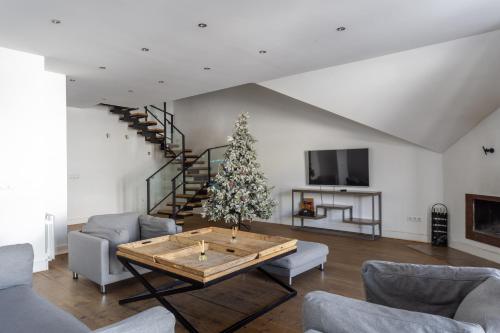 a living room with a christmas tree and a table at PENTHOUSE BY GONDOLA 50 Meters, New Gudauri Suites in Gudauri