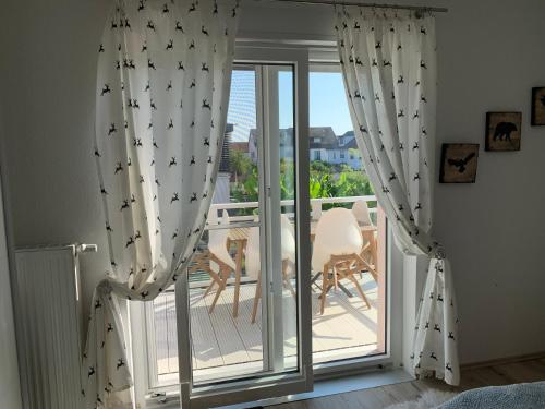 Cette chambre dispose de rideaux et d'un balcon avec une table. dans l'établissement Carpe diem, à Speyer