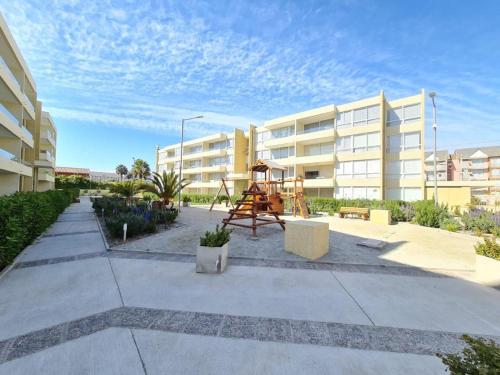 un parque infantil frente a un edificio de apartamentos en Departamento a una cuadra de la Playa, en La Serena