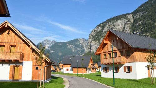 un village avec des bâtiments en bois et des montagnes en arrière-plan dans l'établissement Holiday Homes Obertraun/Oberösterreich 86, à Obertraun