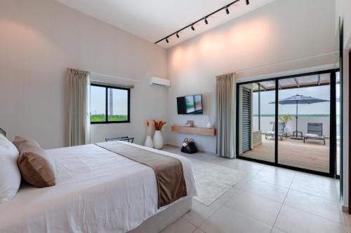 a bedroom with a large bed with a view of the ocean at Areia Boutique Hotel - Puerto Morelos in Puerto Morelos