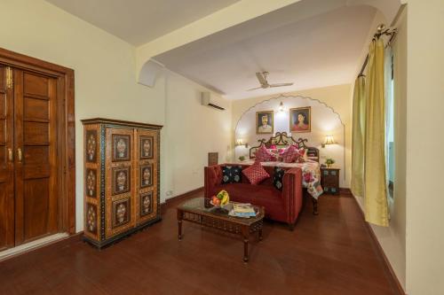 - un salon avec un canapé rouge et une table dans l'établissement Dera Rawatsar - Heritage Hotel, à Jaipur