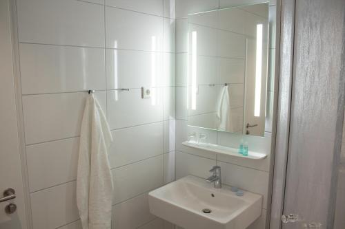 bagno bianco con lavandino e specchio di Cuxlandhotel Doppelzimmer 117 a Dorum-Neufeld