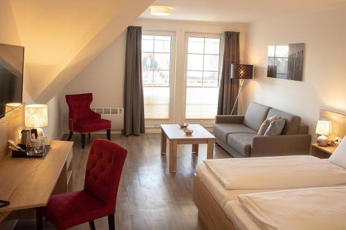 une chambre d'hôtel avec un lit et un canapé dans l'établissement Cuxlandhotel Studio 122, à Dorum Neufeld