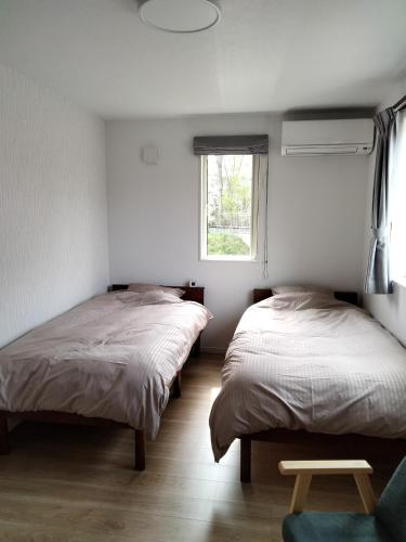 twee bedden in een kamer met een raam bij Guesthouse Senba - Vacation STAY 16651 in Mito