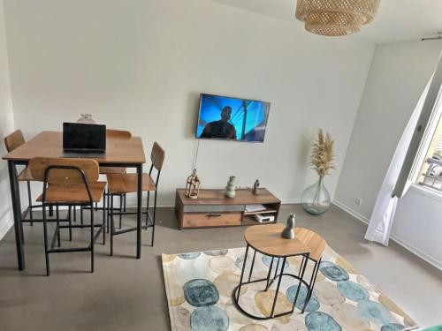 een woonkamer met een tafel en stoelen en een televisie bij T2 Charmant avec Style in Persan