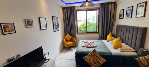 een slaapkamer met een bed, een bank en een raam bij Luxueux Appartement DOWNTOWN RABAT in Rabat