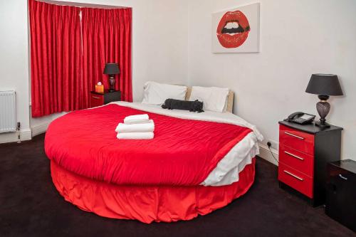 una camera da letto con un letto rosso e asciugamani di G Boutique Hotel a Portsmouth