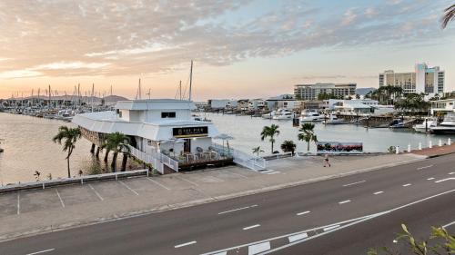 The Pier Pods on the water- 50m from Townsville bus terminal and ferry terminal في تاونزفيل: مبنى بجانب نهر به مرسى