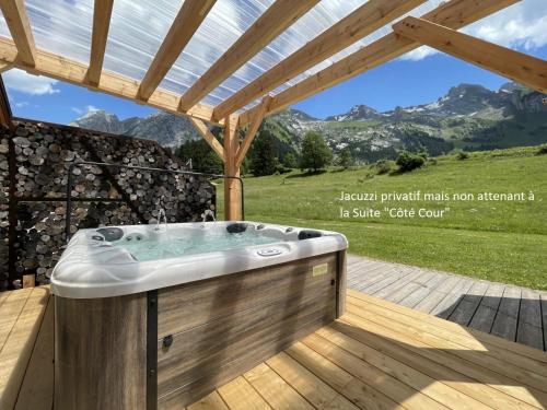 un jacuzzi en una terraza con montañas en Chalet-Hôtel Inarpa, en La Clusaz