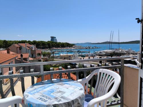 uma mesa e cadeiras numa varanda com vista para um porto em Apartments & Room Marina View em Vodice