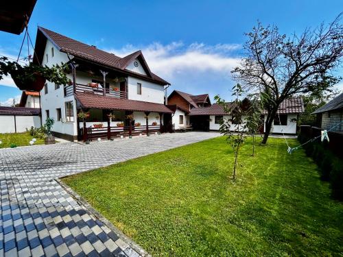 uma casa com um relvado verde em frente em Casa Chindris em Ocna Şugatag