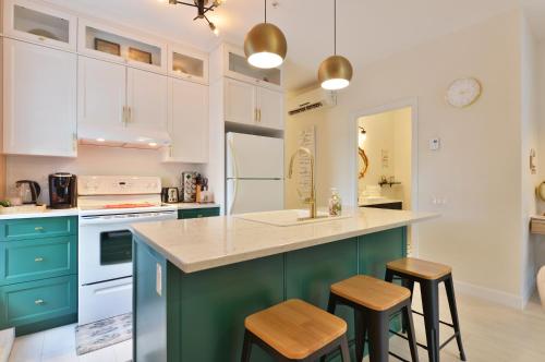 una cocina con armarios y taburetes verdes y blancos en La vie est belle: FREE PARKING, GYM, ROOFTOP TERRACE, en Quebec