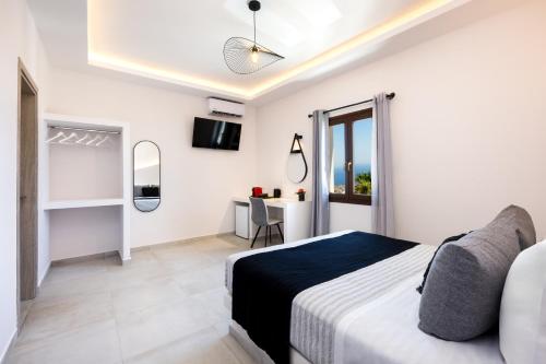 una camera bianca con letto e scrivania di Santorinn Suites Fira a Firà