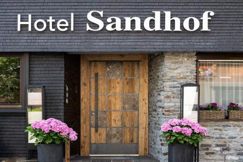 a hotel santilli with flowers in front of a door at Hotel Sandhof in Lech am Arlberg