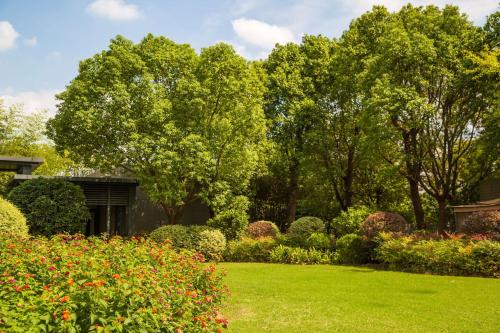 上海市にあるDoubletree By Hilton Shanghai Hongqiaoの緑草・花・木々のある庭園