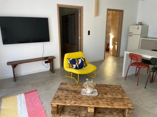 Sala de estar con silla amarilla y mesa en Casaty Mare, en Porto Vecchio