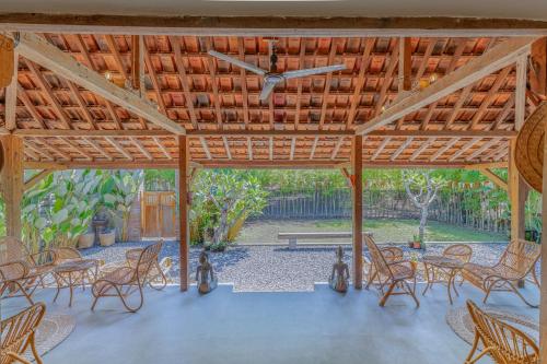 een groot houten paviljoen met stoelen en een tafel bij Yukke Tembi Homestay in Yogyakarta