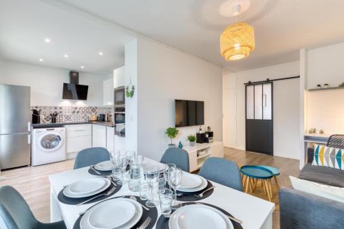 een eetkamer en een keuken met een tafel en stoelen bij Appartement tout confort - Parking privé gratuit in Rouen