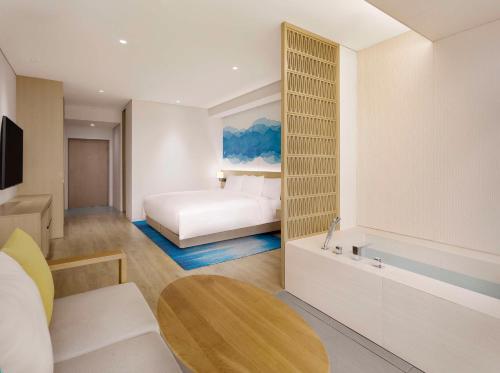 Habitación de hotel con cama y bañera en Cassia Sokcho, en Sokcho