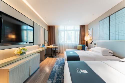 A bed or beds in a room at Echarm Hotel Guangzhou Panyu Shiqiao Subway Store