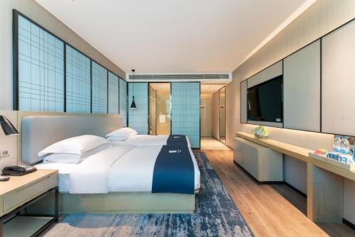 A bed or beds in a room at Echarm Hotel Guangzhou Panyu Shiqiao Subway Store