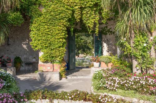 uma entrada para um jardim com flores e plantas em Hotel Parsifal - Antico Convento del 1288 em Ravello