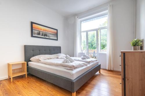 um quarto com uma cama e uma grande janela em Großes Apartment mit 2 Balkonen zentral am Nordertor em Flensburg