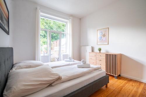 um quarto com uma cama grande e uma janela em Großes Apartment mit 2 Balkonen zentral am Nordertor em Flensburg