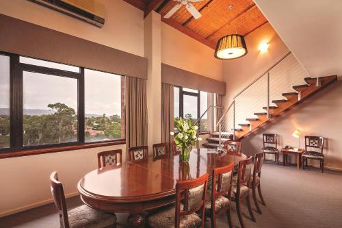 una sala da pranzo con tavolo, sedie e finestre di Arkaba Hotel a Adelaide