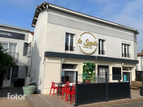 um edifício branco com uma mesa em frente em Hôtel Le Smile em Saint-Vincent-Sterlanges