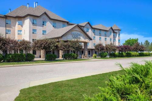 un gran edificio con una carretera delante en Days Inn & Suites by Wyndham West Edmonton, en Edmonton