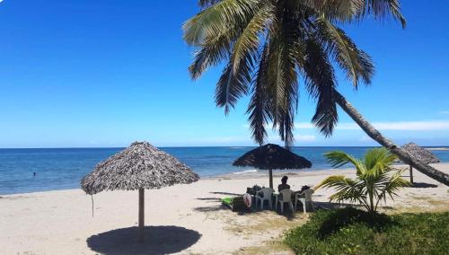 uma praia com cadeiras e guarda-sóis e o oceano em MAHAMBO BEACH hôtel em Mahambo