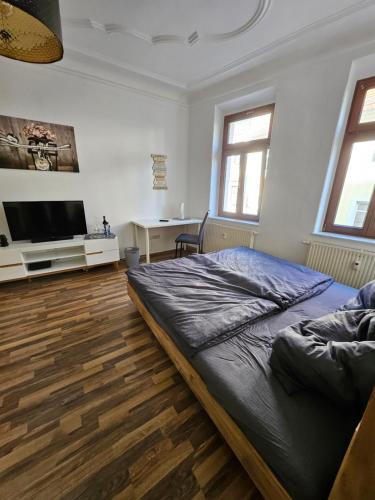 una camera con letto e scrivania di FERIENWOHNUNG APARTMENT in ZITTAUER STADTZENTRUM INNENSTADT INNENRING TOP LAGE - WOHNEN AUF ZEIT IN ZITTAU - 1 RAUM WOHNUNG a Zittau