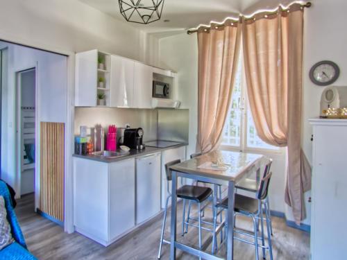 una pequeña cocina con mesa y sillas en una habitación en La petite Maison, en Grenoble