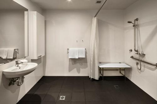 een witte badkamer met een wastafel en een toilet bij Quest Bella Vista in Baulkham Hills