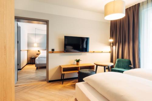 a hotel room with a bed and a desk at harry's home Graz-Smart City hotel & apartments in Graz