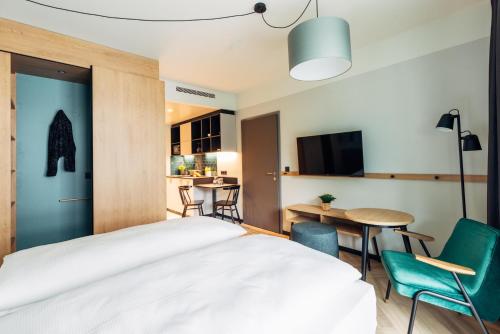 a bedroom with a bed and a table and chairs at harry's home Graz-Smart City hotel & apartments in Graz